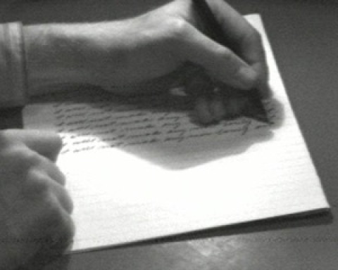 A person writing on a piece of paper.