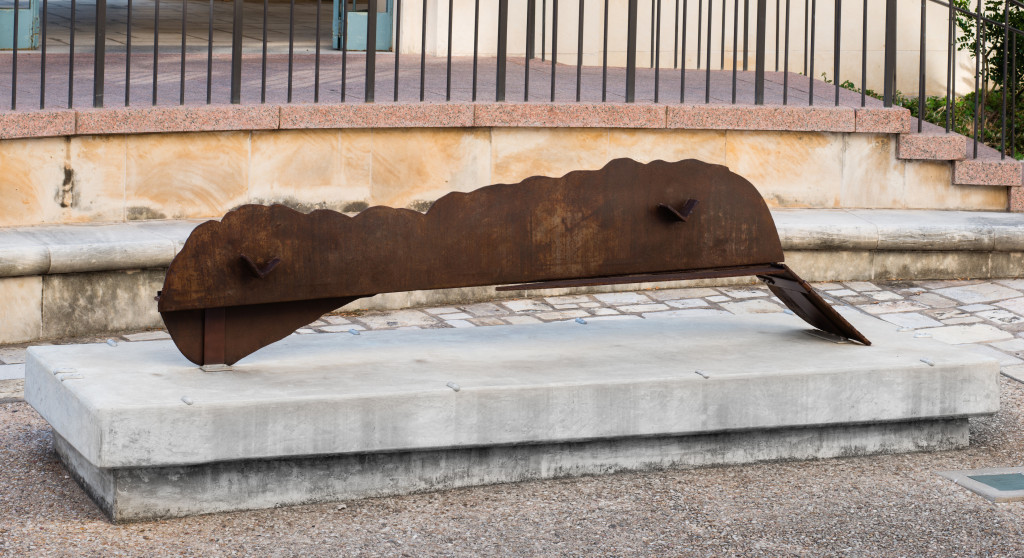 A brown sculpture on a concrete base