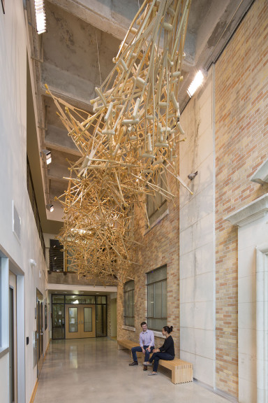 Wooden crutches combined into a spoke pattern hanging from the ceiling of an atrium