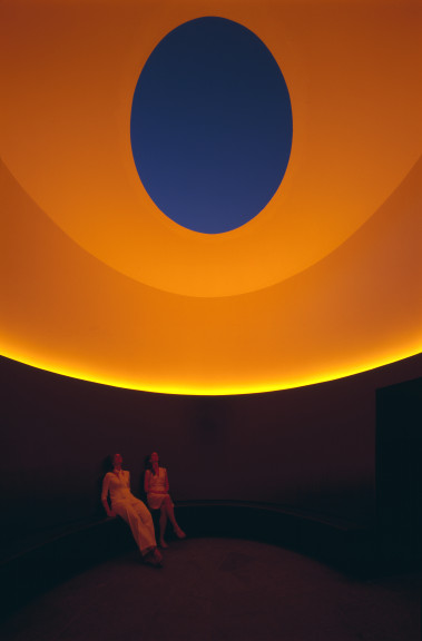 two people sitting in orange lit room