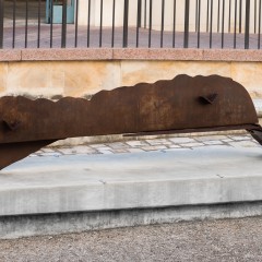 A brown sculpture on a concrete base
