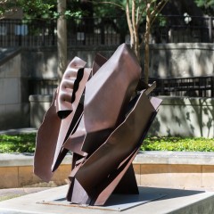 A brown sculpture on a cement base