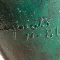 A detail of the sculpture which shows the artist's signature welded in and painted green.