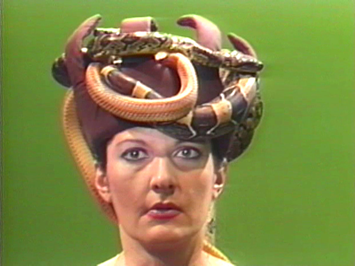 A woman with a hat covered in snakes.