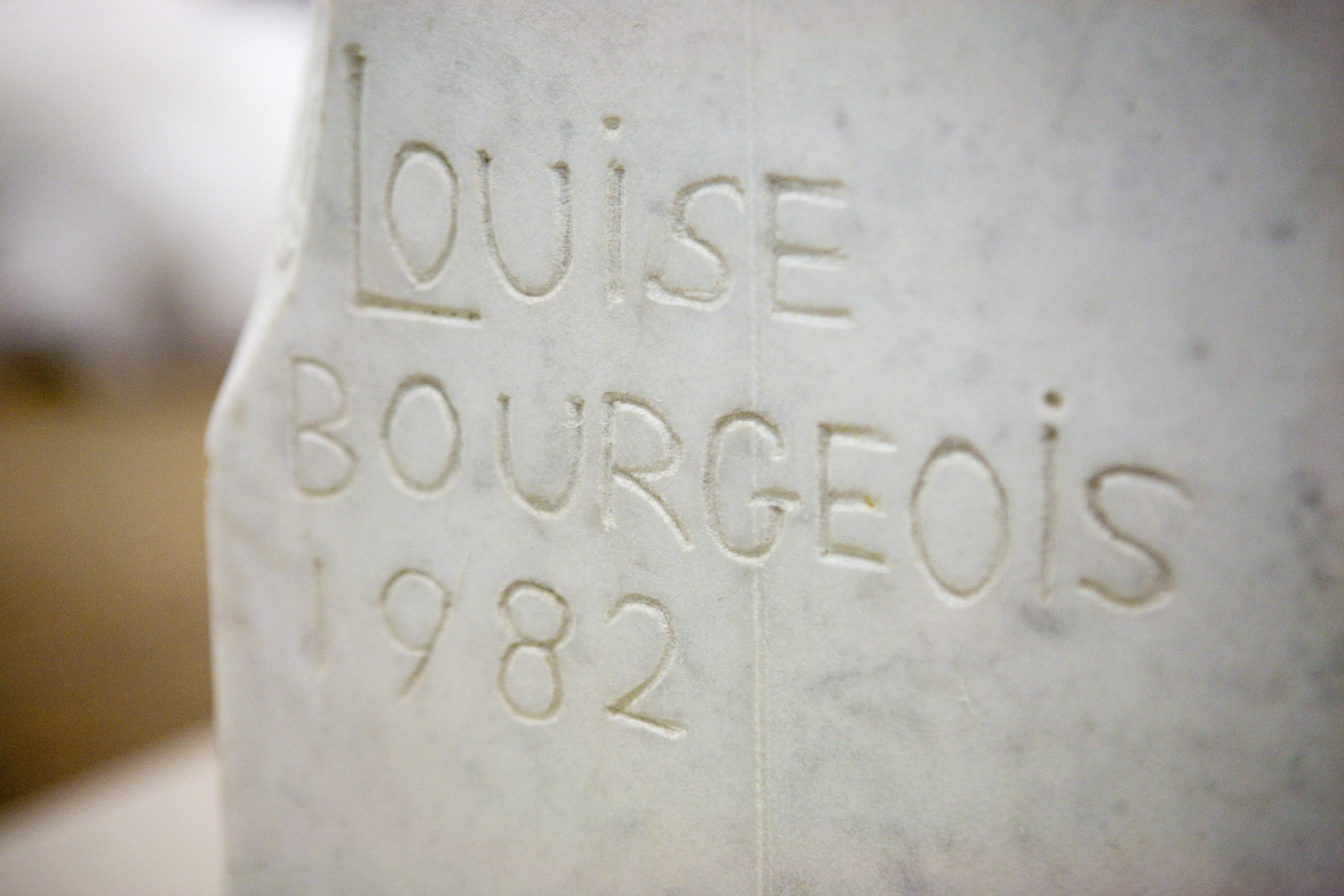 A detail of Louise Bourgeois' sculpture "Eyes" showing her carved signature and date of creation