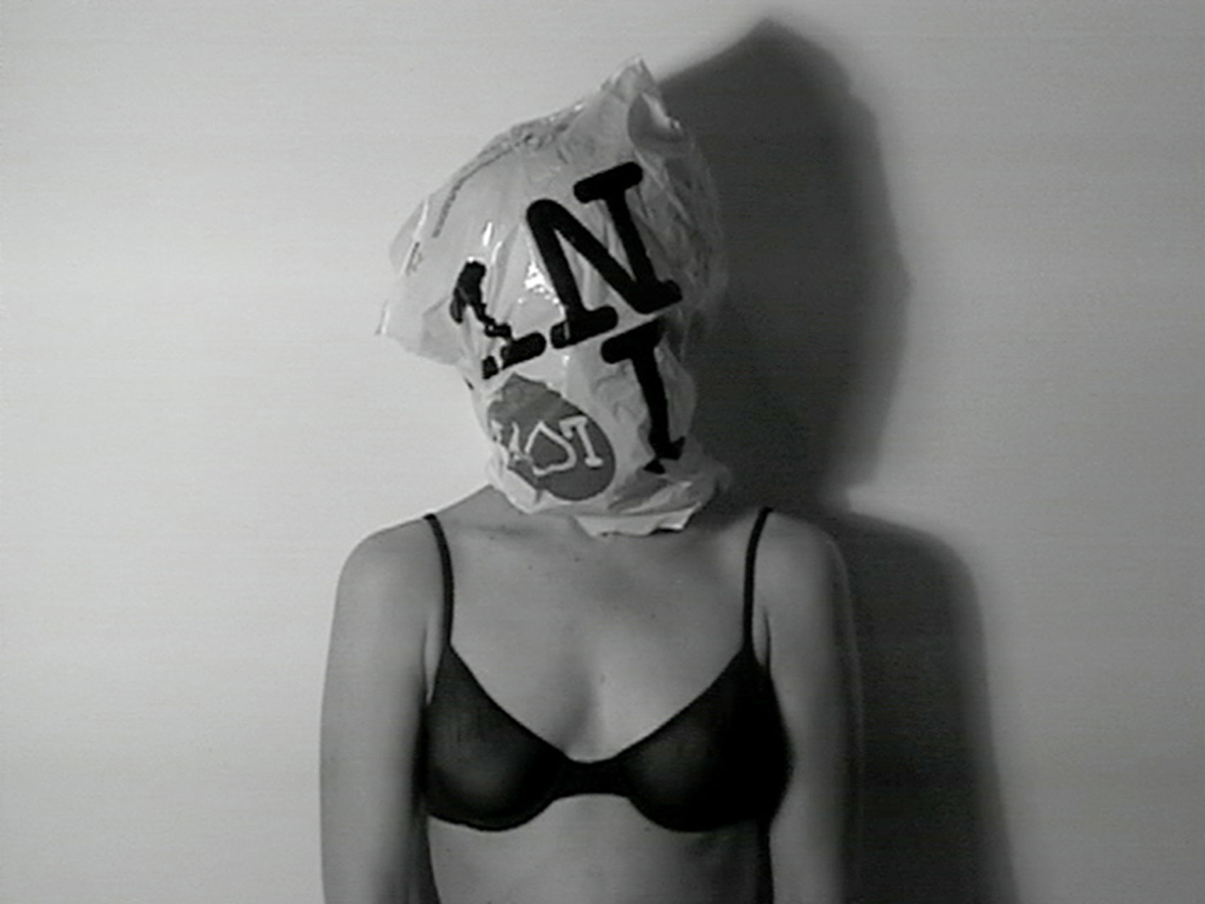 A woman in a bra with a plastic bag over her head