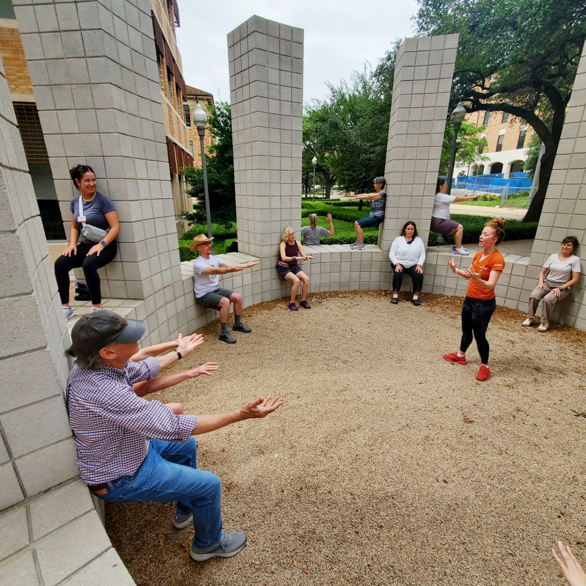 A group of people do wall sits in Sol LeWitt's "Circle with Towers"