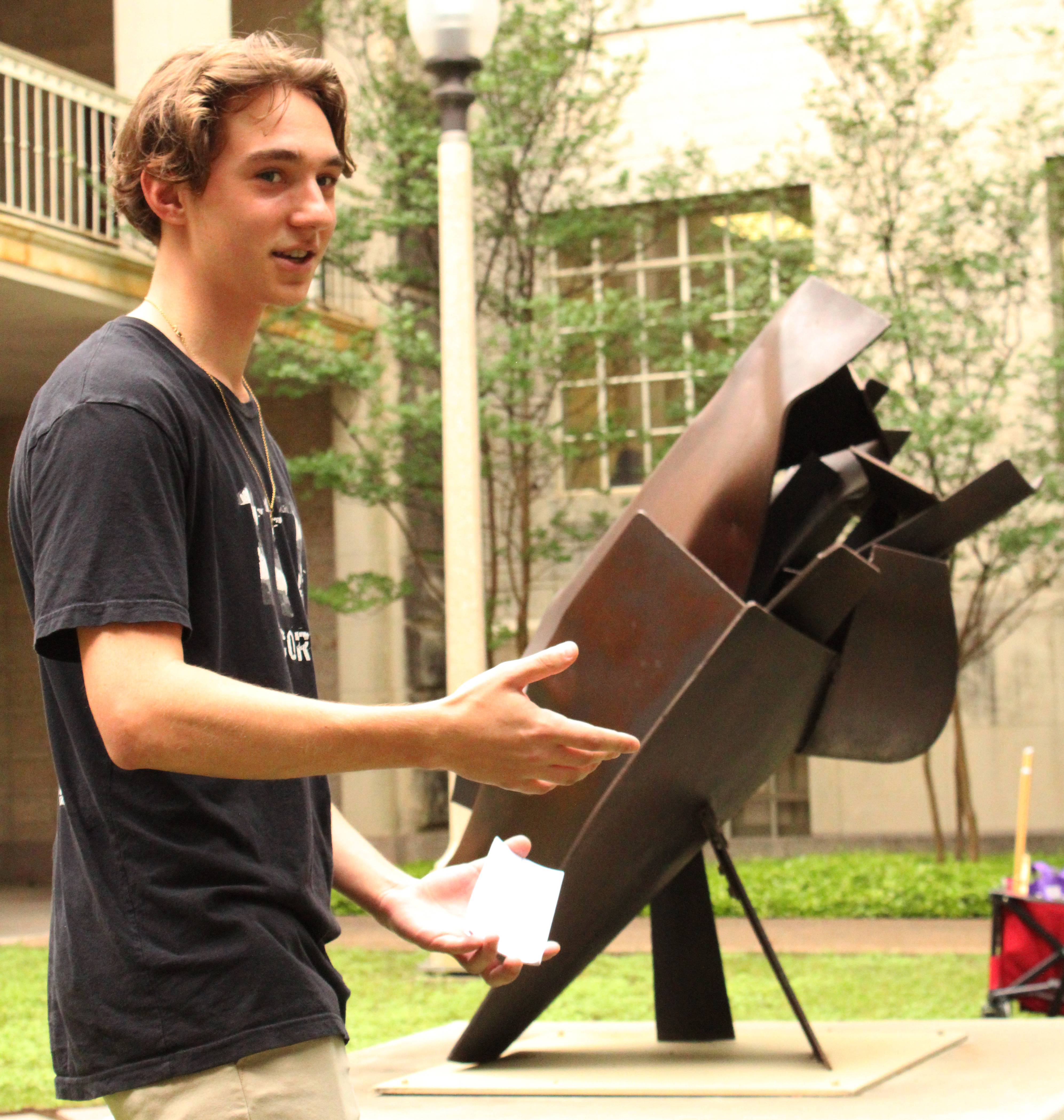 A student presents in front of "Eleanor at 7:15"; a steel sculpture