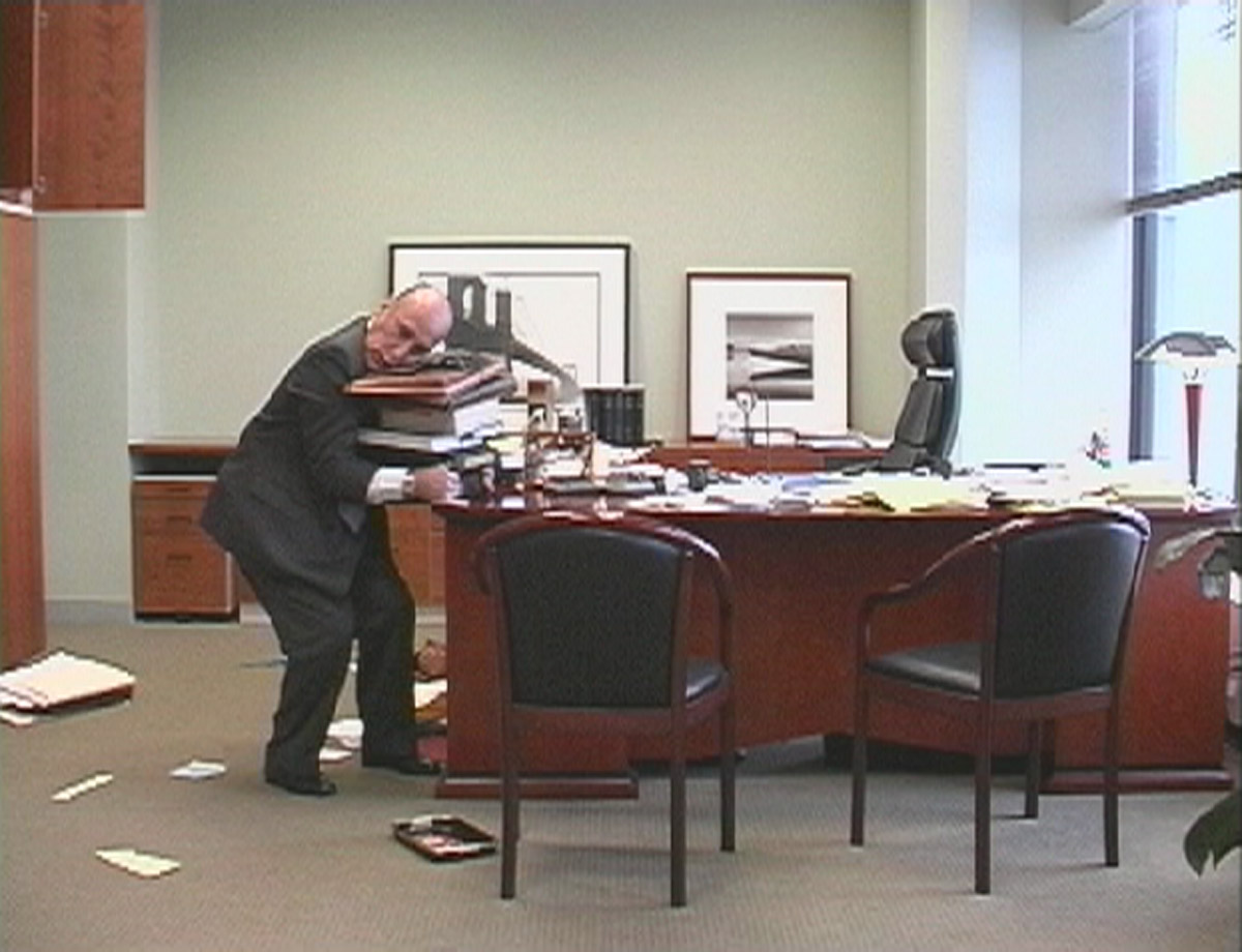 man picking up files from desk