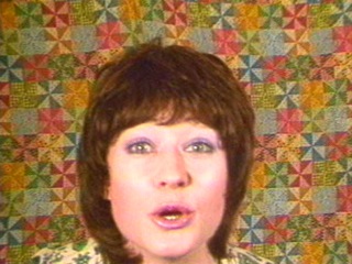 The head of a woman in front of a patterned wall