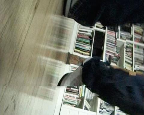 A sideways leg in front of a bookshelf