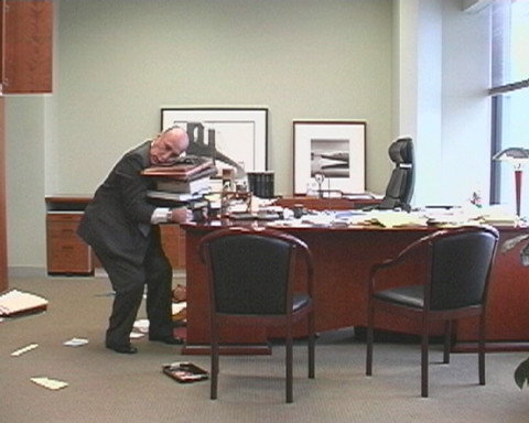 man picking up files from desk