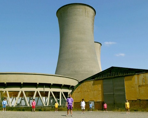 children standing in front of nuclear power plant