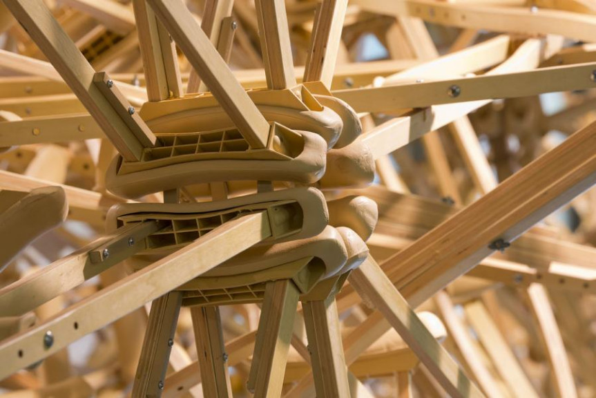 A hanging sculpture made out of wooden crutches