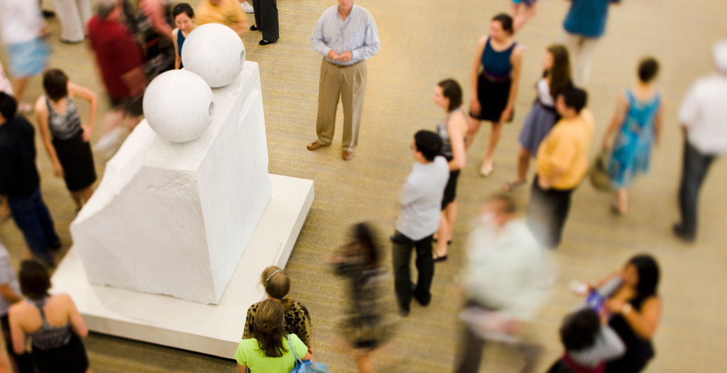 People standing around a large marble sculpture
