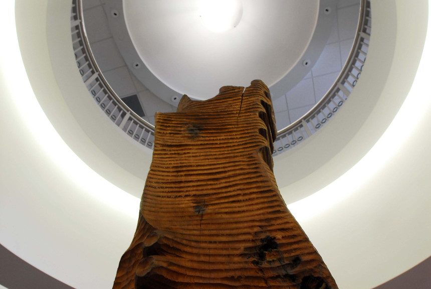 thin wooden sculpture from bottom of frame looking up into oculus of room
