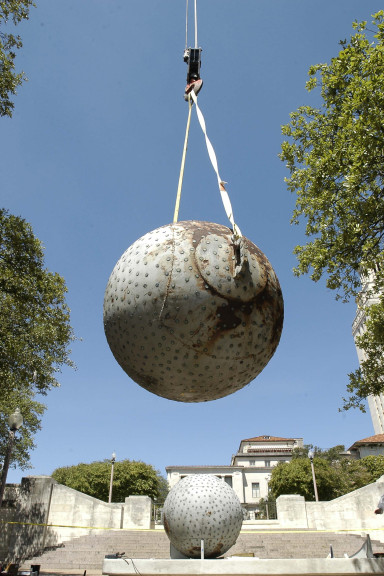Giant sphere held in place in the air with crane ropes