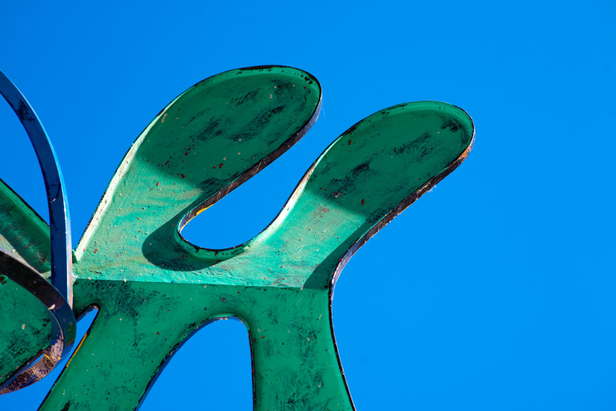 Green curvy surface with blue sky in background