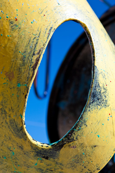 Bright yellow surface framing an empty circle with blue sky shining through