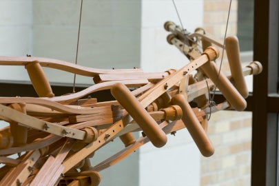 A hanging sculpture made out of wooden crutches