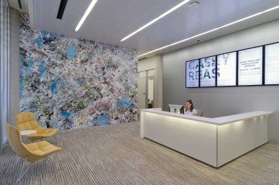 A large digital mural with a woman behind an administrative desk