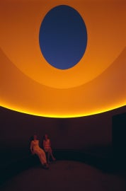 two people sitting in orange lit room