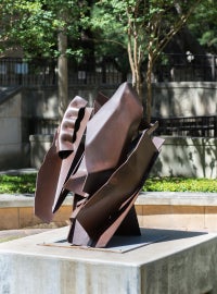A brown sculpture on a cement base