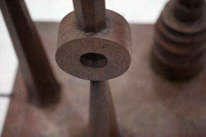 Detail of a tall sculpture with three large vertical poles