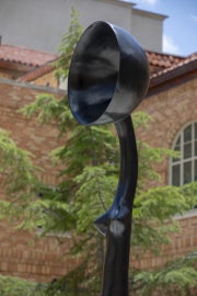 A detail of Simone Leigh's Sentinel IV. In this image the work is seen from the right and shows the figure from the stomach up, with a side view of the bowlcrown. 