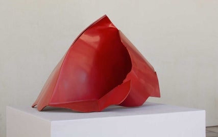 A red sculpture on a pedestal 