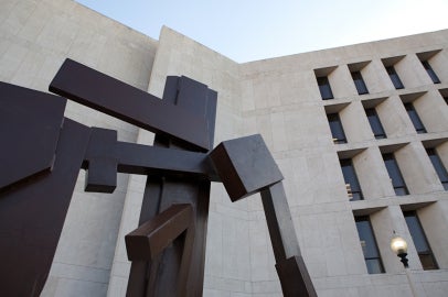 flat brown surface sculpture up against limestone building