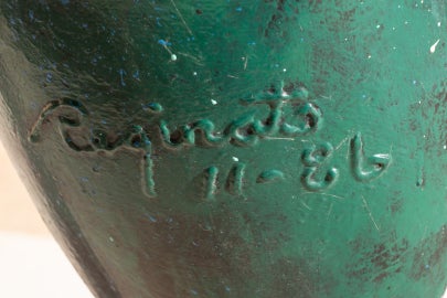 A detail of the sculpture which shows the artist's signature welded in and painted green.