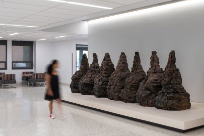 An installation view of Seven mountain shaped objects made from wood blocks
