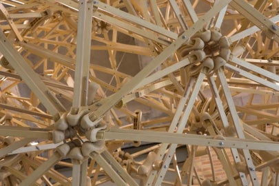 A hanging sculpture made out of wooden crutches