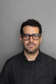 A man with short dark hair and glasses