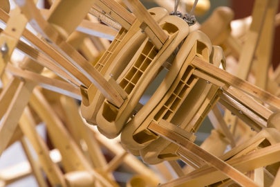 A hanging sculpture made out of wooden crutches