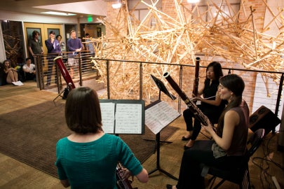 Musicians in front of a crutch sculpture