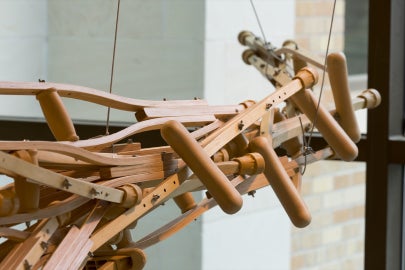 A hanging sculpture made out of wooden crutches
