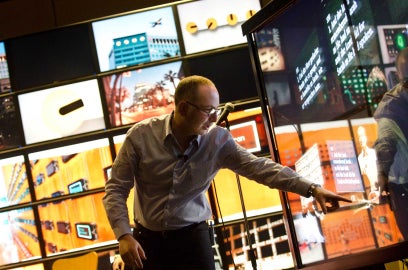 A man pointing in front of digital screens