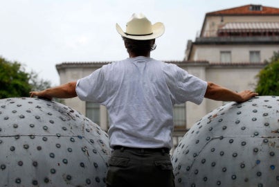 A man touching two large metal balls