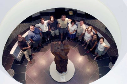 People standing around a sculpture and looking up into a rotunda