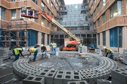 bricks in circular form with people leaning over different parts