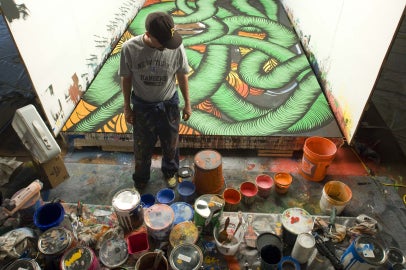 person standing behind paint cans