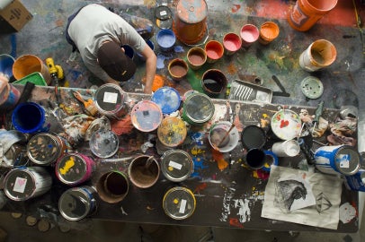 person leaning over paint cans
