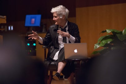 person sitting in chair on stage looking to the left
