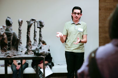 person gesturing to sculpture