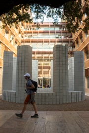 person walking past outdoor sculpture