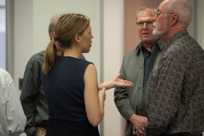 four people standing in circle and talking