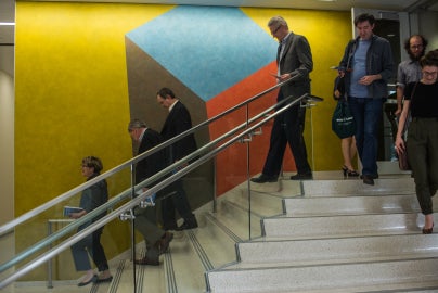people walking down stairs in front of colored wall