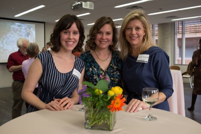 three people standing around table